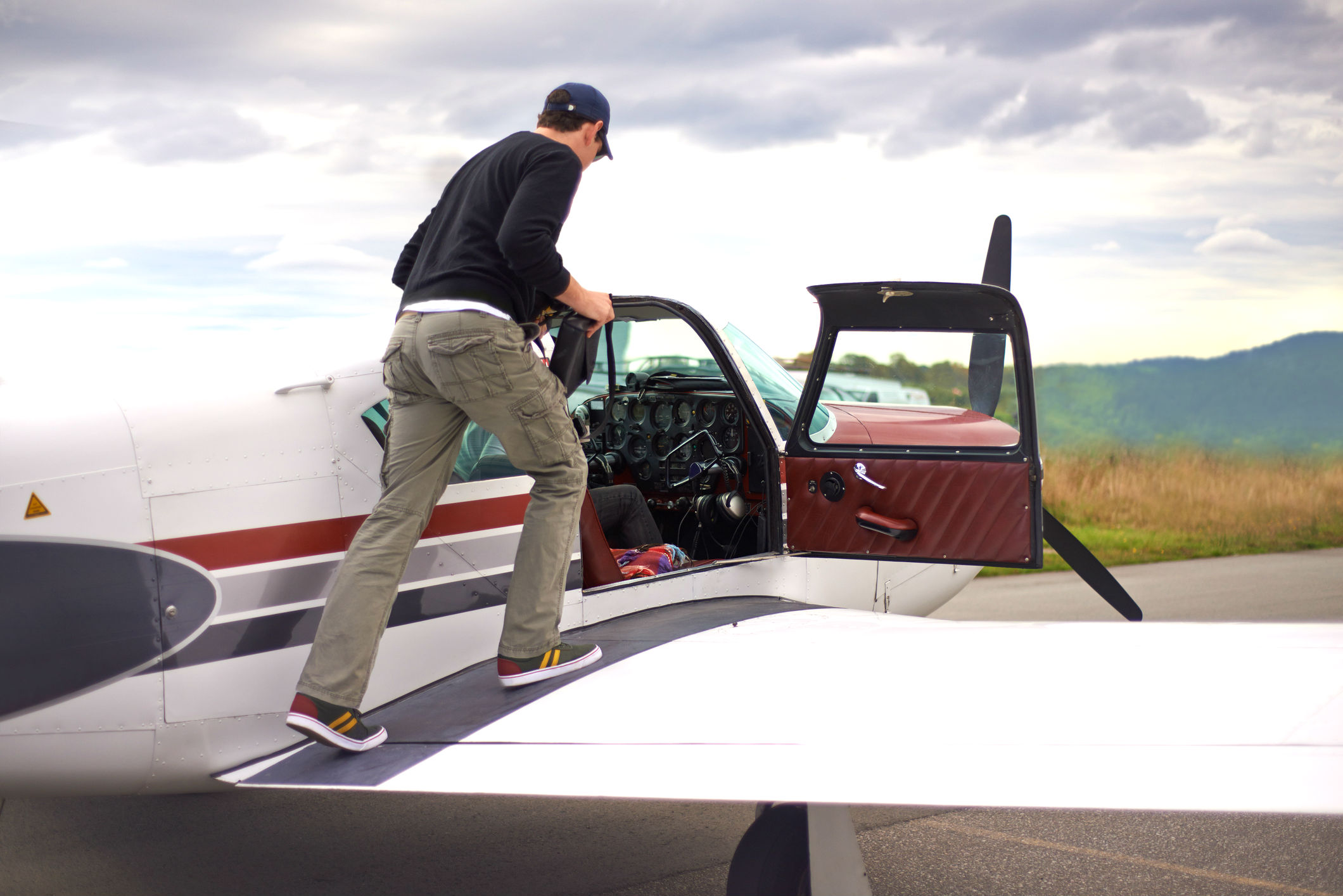 A pilot stands on the wing of his private aircraft